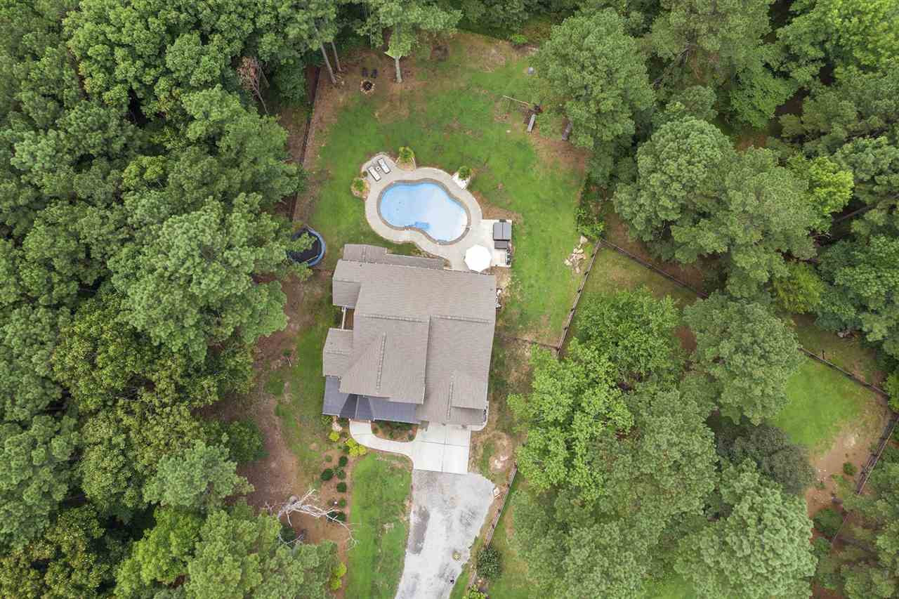 Overhead aerial of the home, pool and wooded lot